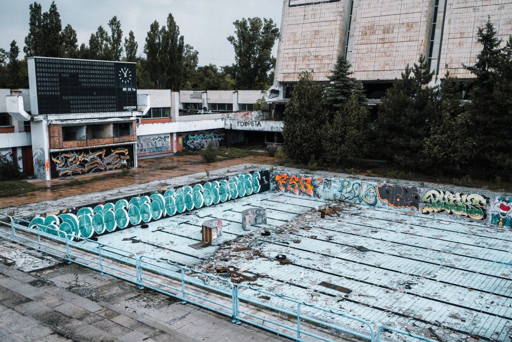 Verlassenes Schwimmbecken mit Graffiti und Betonarchitektur in Sofia Urban Exploration Fotografie